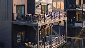 A multi-level building with outdoor seating, a balcony, and a hot tub. - Smoky Mountain Cabin With Indoor Pool + Hot Tub + Views Dolly's Dreamhouse by Avantstay (Sevierville)