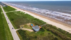 An aerial view of a coastal property with a road, beach, and ocean. - Private Beachfront Home with Ocean Views & Pool (Surfside)