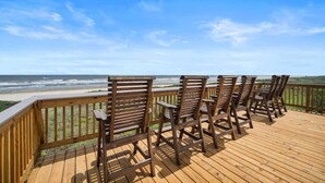 A wooden deck with four wooden chairs facing a beach view. - Private Beachfront Home with Ocean Views & Pool (Surfside)