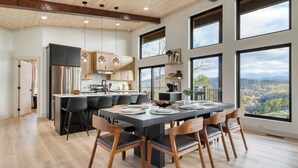 Una cocina moderna con una isla central, ventanas amplias y un comedor con vistas.
