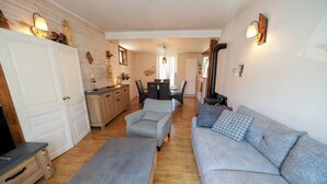 Un vaste espace de vie comprenant un canapé, un fauteuil et une table à manger.