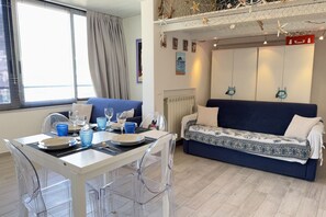 A room with a dining table set for two, a sofa, and a bed. - Alassio Centre, Ideal for Families (Alassio)
