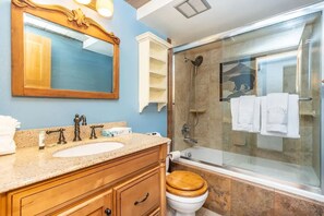 A bathroom with a wooden vanity, a large mirror, a glass shower enclosure, and a white toilet. - Top Floor, End Unit Condo with Amazing Mountain Views (Silverthorne)