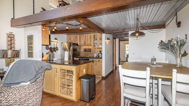 A spacious kitchen with wooden cabinets, a central island, and pendant lighting. - Top Floor, End Unit Condo with Amazing Mountain Views (Silverthorne)