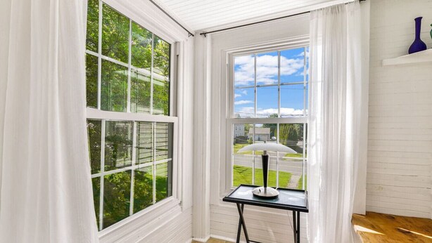 A room with large windows, a small table with a lamp, and a wooden floor. - SUNNY PRIVATE 1 BEDROOM APARTMENT (Portland)