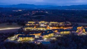 Vue aérienne d’un complexe hôtelier comprenant plusieurs bâtiments, un parking et un lac.