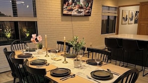 A dining area with a round table, black chairs, and a painting on the wall.