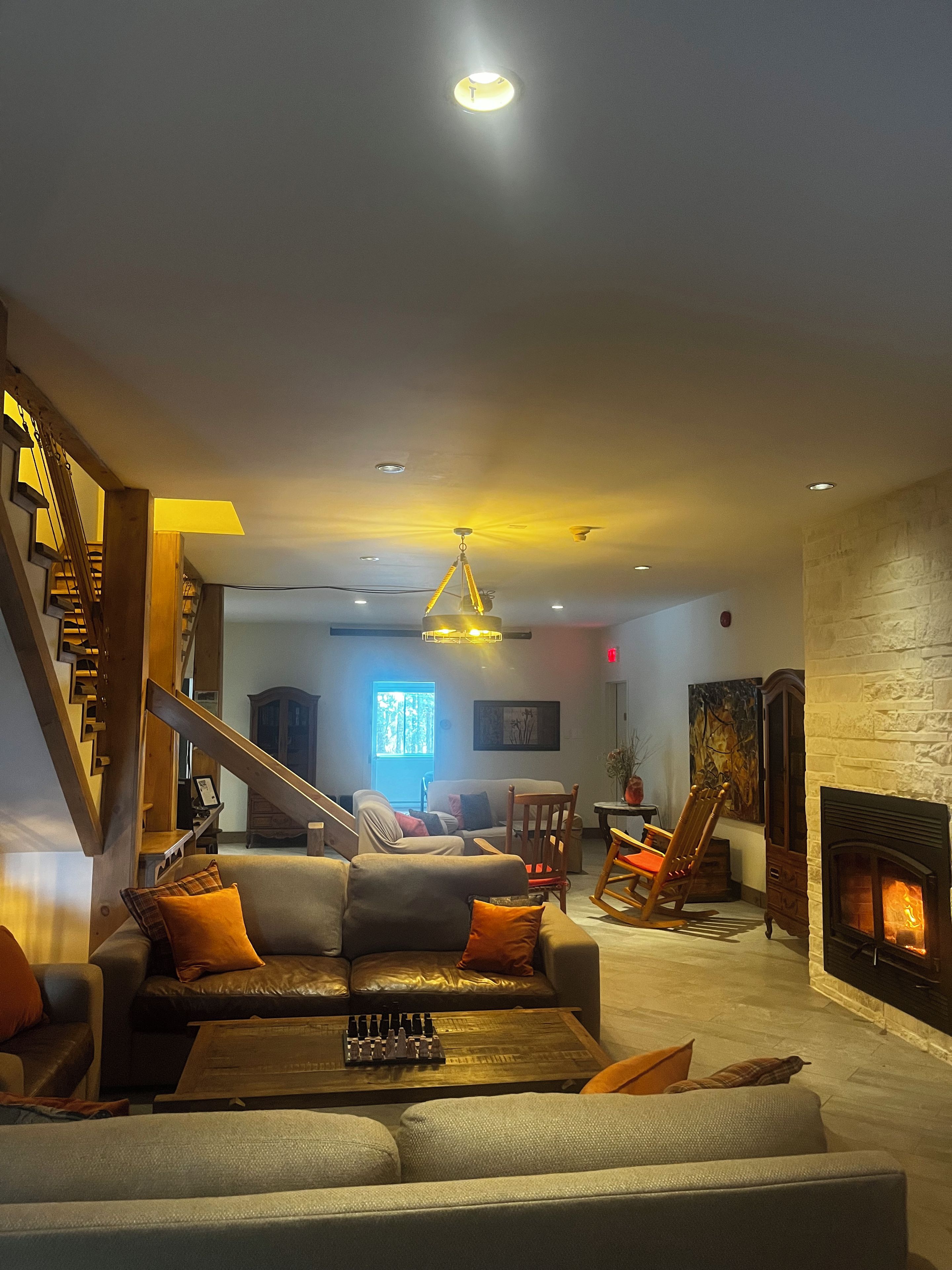 Una sala de estar con chimenea, una escalera y un comedor.