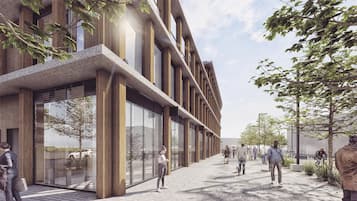 Un edificio moderno con fachada de vidrio, detalles de madera y un camino pavimentado.