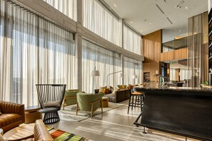 A modern interior with a bar area, seating, and large windows. - The Clayfield, in the Unbound Collection by Hyatt (Niagara-on-the-Lake)