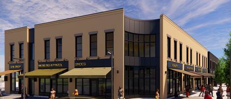 A modern building with storefronts for a toy shop, women's apparel, and shoes.