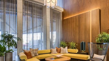 Un interior moderno con un sofá modular, una mesa de centro redonda y una pared de acento de madera.