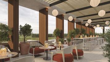 An outdoor dining area with multiple tables and chairs, large wooden columns, and hanging lanterns.