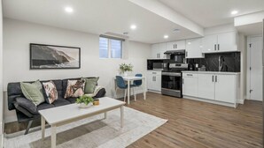 A modern apartment with a living room, dining area, and kitchen.