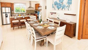 A modern kitchen with a dining area, a ceiling fan, and a large window. - Sleeps up to 14 | 4 King Suites & Private Pool (Sosúa)