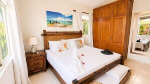 A bedroom with a bed, nightstands, a wardrobe, a painting, and a window with curtains. - Sleeps up to 14 | 4 King Suites & Private Pool (Sosúa)