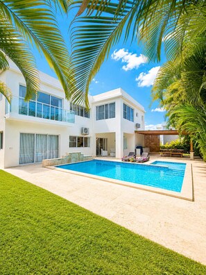 A modern two-story house with a swimming pool, a covered patio, and lush greenery. - 5bd Corner Lot Villa|Private Pool, Sleeps up to 14 (Sosúa)