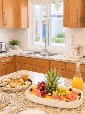 A kitchen with wooden cabinets, a granite countertop, a sink, a toaster, and a fruit platter. - 5bd Corner Lot Villa|Private Pool, Sleeps up to 14 (Sosúa)