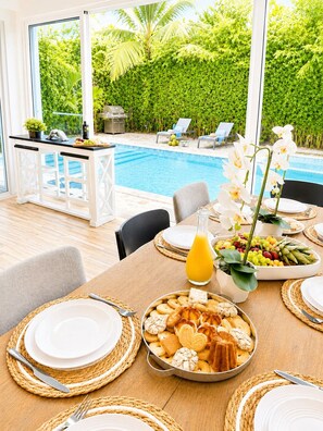 A dining area with a pool view, a bar, and a tropical garden. - Sleeps up to 9 | Family Retreat, Pool & Jacuzzi (Sosúa)