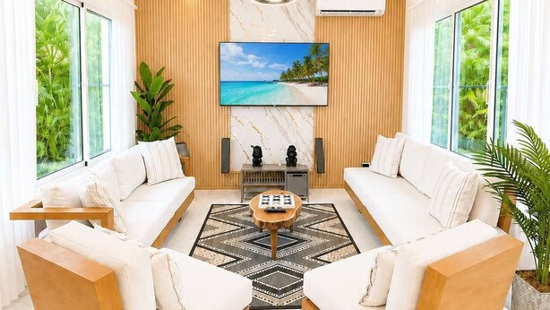A modern living room with a sofa set, a coffee table, and a TV mounted on the wall.