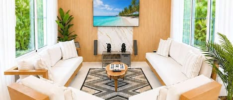 A modern living room with a sofa set, a coffee table, and a TV mounted on the wall.