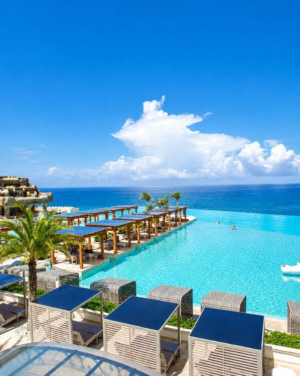 A resort with a pool, lounge chairs, and a view of the ocean. - Bali Villa | Sunken Lounge & 3 King Beds in SOV (Sosúa)