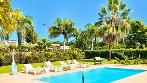 A swimming pool with lounge chairs and palm trees. - Private Pool Villa | Large Yard & Sleeps up to 9 (Sosúa)
