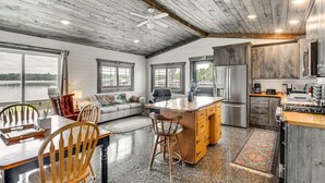 A spacious kitchen with a large island, wooden ceiling, and a view of a lake. - Cozy Cabin on Big Pine Lake w/ Dock & Fire Pit! (New York Mills)