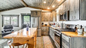 A spacious kitchen with wooden cabinets, a large island, stainless steel appliances, and a view of the outdoors. - Cozy Cabin on Big Pine Lake w/ Dock & Fire Pit! (New York Mills)