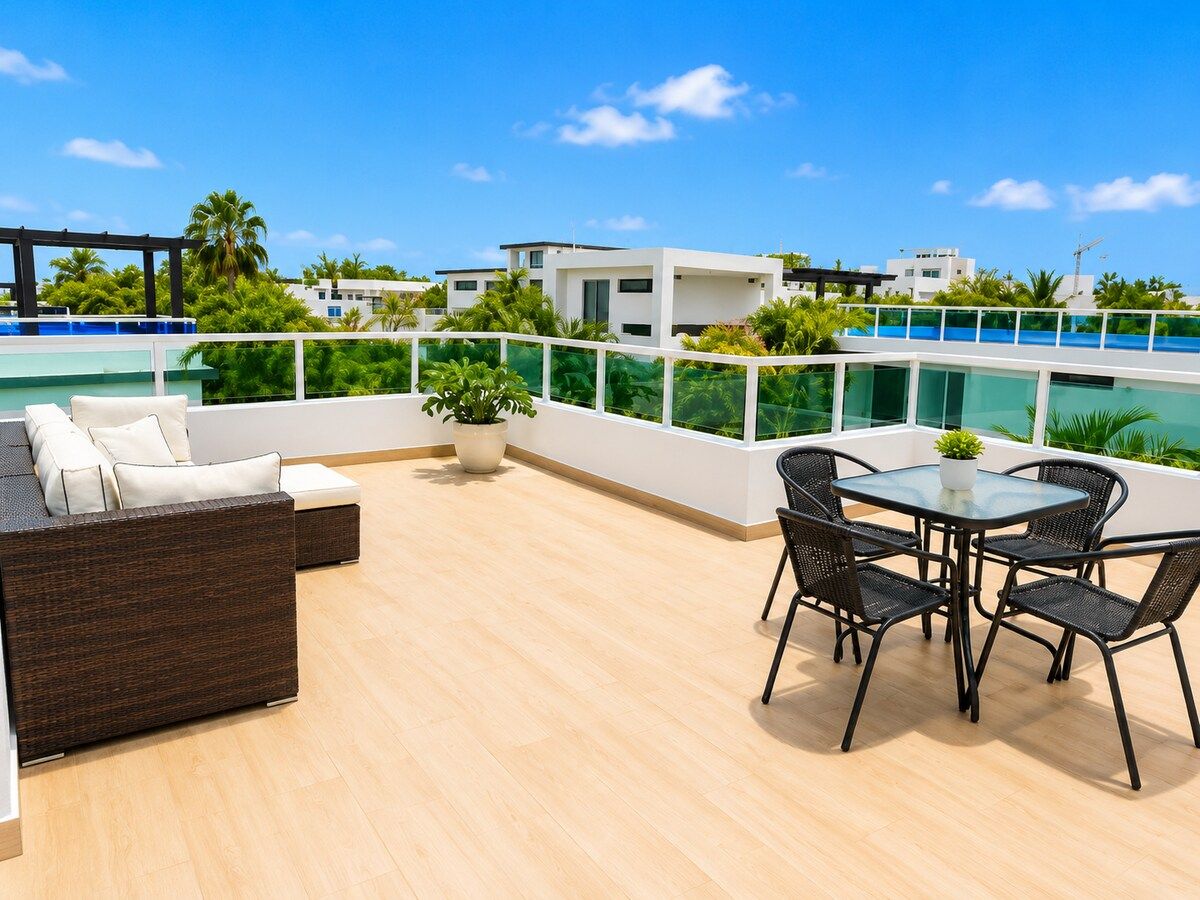 A rooftop terrace with a pool, outdoor furniture, and a view of the city.