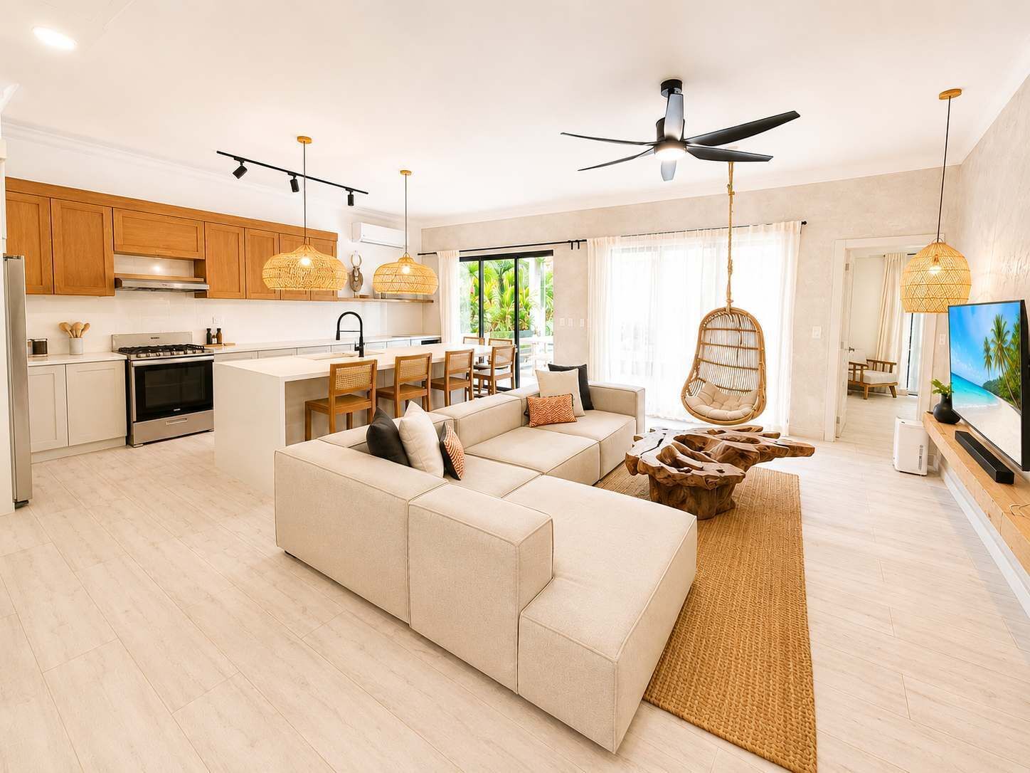 Um espaço de estar moderno com sofá, sala de jantar, cozinha e televisão.