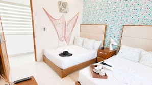 Une chambre d’hôtel avec deux lits, un ventilateur de plafond, un mur décoratif et une petite table avec un plateau.