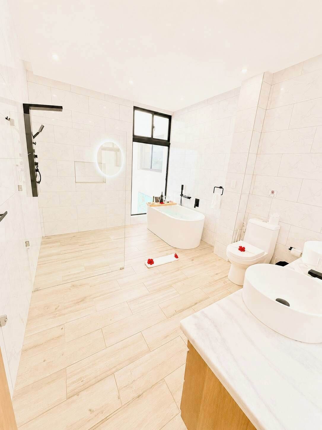 A modern bathroom with a freestanding bathtub, a toilet, and a shower area.