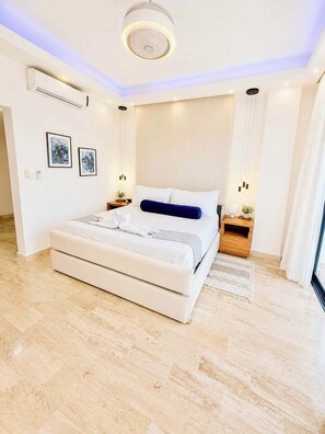 A modern bedroom with a large bed, bedside tables, and artwork on the wall. - Sleeps up to 40 |8BR, Mini Golf & Largest Pool SOV (Sosúa)