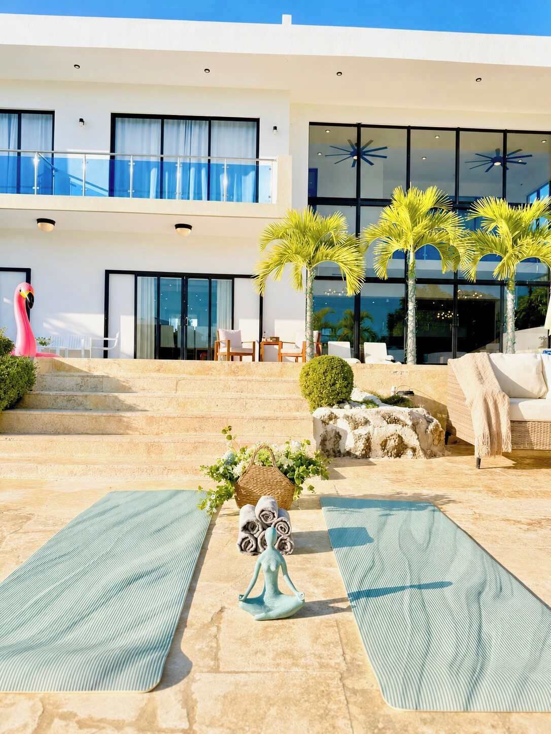 A modern outdoor area with a pool, seating, and palm trees.