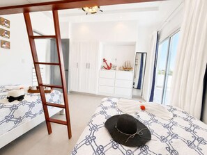 A bedroom with two beds, a wooden ladder, a wardrobe, and a view through a window. - Sunset Villa | Bunk Room, Pool & Sleeps up to 11 (Sosúa)
