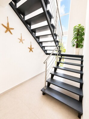 A modern staircase with black steps and a metal railing, leading to a balcony with a view of the sky. - Sunset Villa | Bunk Room, Pool & Sleeps up to 11 (Sosúa)