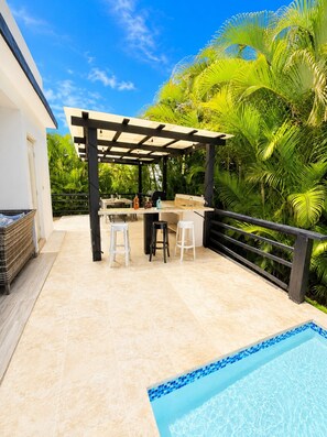 An outdoor patio with a pool, a pergola, and a bar area. - Sunset Villa | Bunk Room, Pool & Sleeps up to 11 (Sosúa)