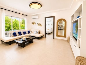 A modern living room with a sofa, coffee table, and a TV. - Sunset Villa | Bunk Room, Pool & Sleeps up to 11 (Sosúa)