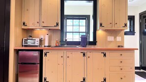 Una cucina con mobili in legno, un frigorifero in acciaio inox e una finestra vista.