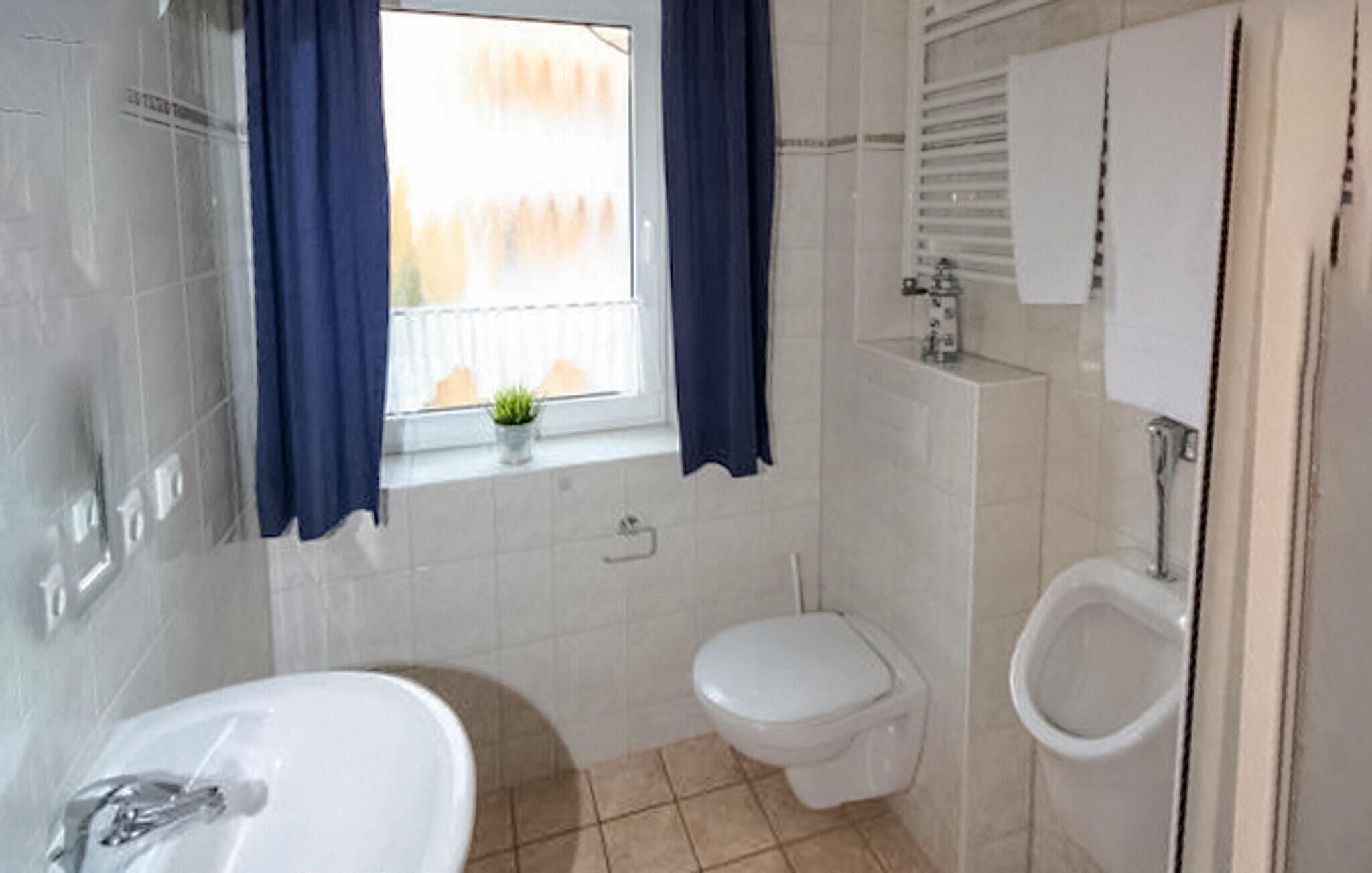 A bathroom with a bathtub, toilet, and bidet.