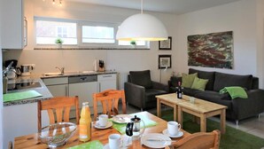 Eine moderne Küche mit Essbereich, einer Couch und einem Couchtisch.
