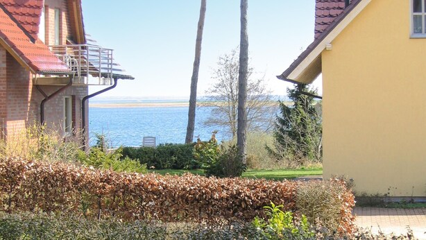 Een woonwijk met een huis, een balkon en uitzicht op zee.