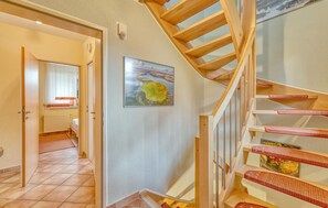 Eine Treppe mit Holzstufen und roten Geländern, die zu einer oberen Etage führt.