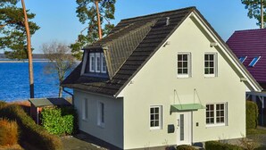 A two-story house with a gabled roof, a front door, and a small porch. - Awesome apartment in Röbel with lake view (Röbel)