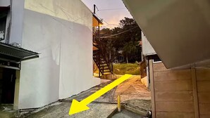 A narrow alleyway with a concrete path leading to a staircase. - A 5 minutos Parque Nacional Manuel Antonio A/C #2 (Quepos)