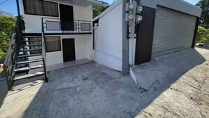 A two-story building with a staircase leading to an upper level. - A 5 minutos Parque Nacional Manuel Antonio A/C #2 (Quepos)