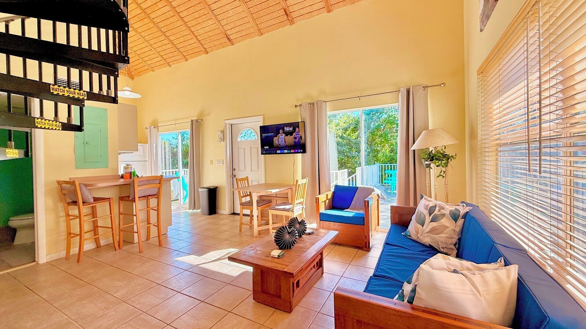 A spacious living area with a dining table, sofa, and TV.