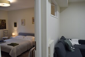 Une chambre à coucher avec un lit, une table de chevet, une lampe et un radiateur.