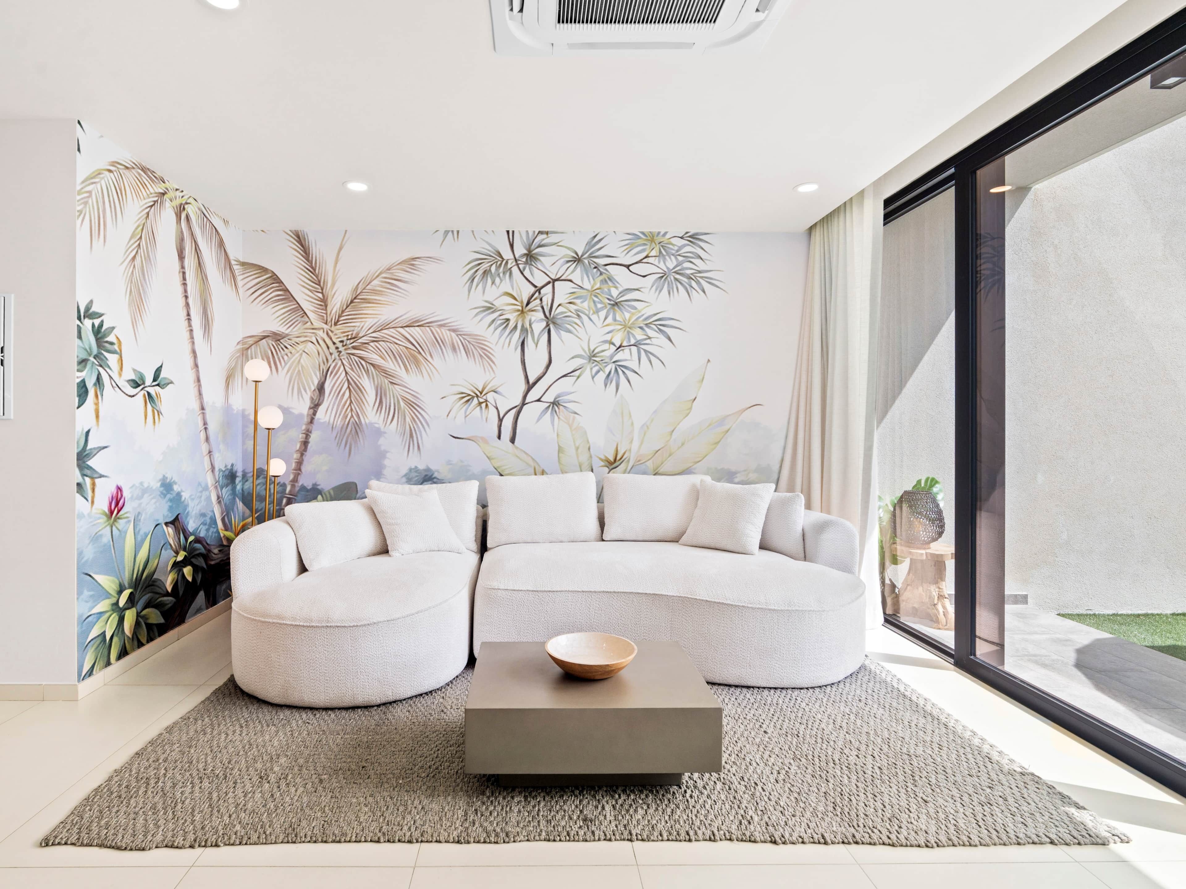 Ein modernes Wohnzimmer mit einem Ecksofa, einem Couchtisch und einem großen Fenster.